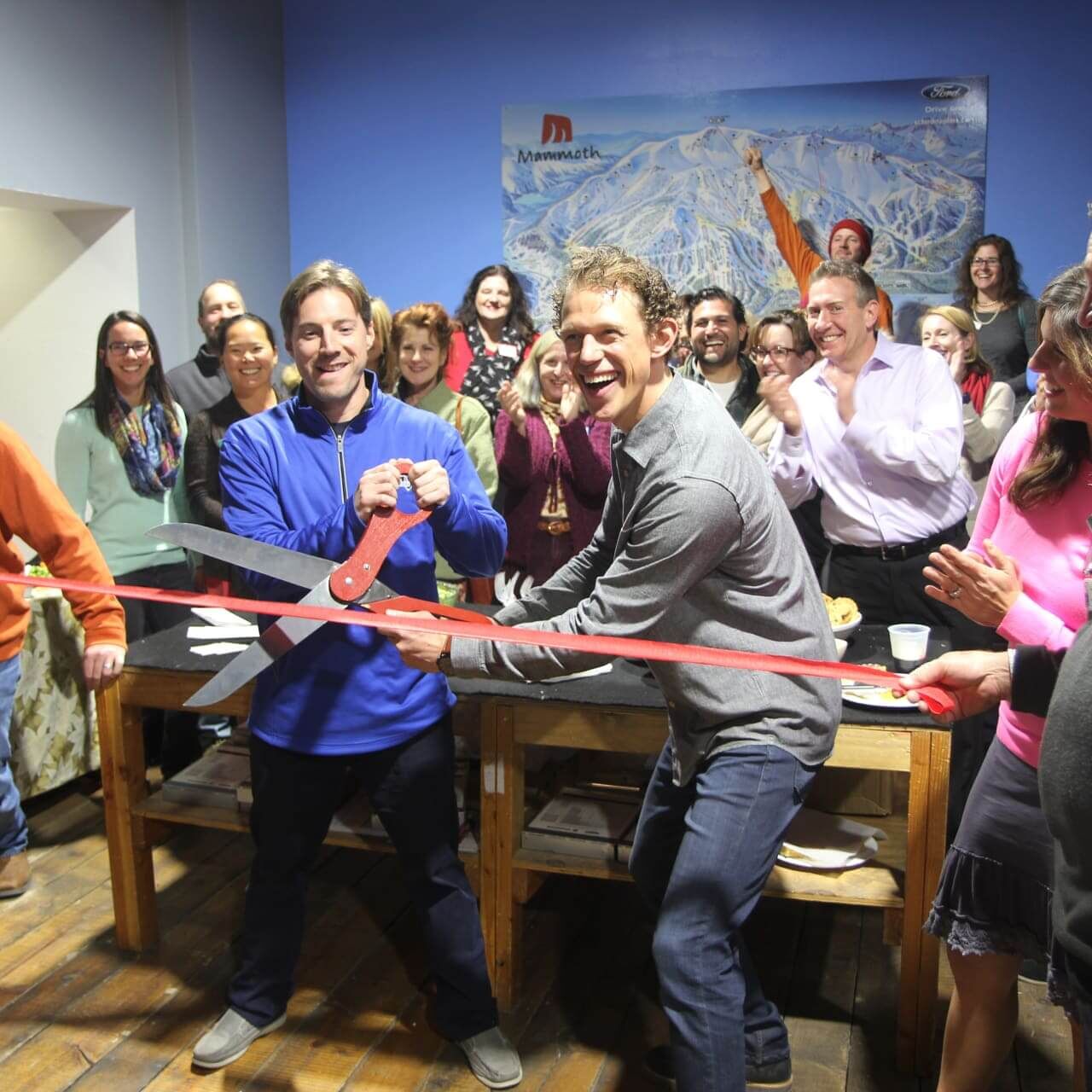 Jeremy Goico and Colin Fernie, owners of Black Tie Ski Rentals, smile as they cut the ribbon with giant scissors for their new shop location on Old Mammoth Road